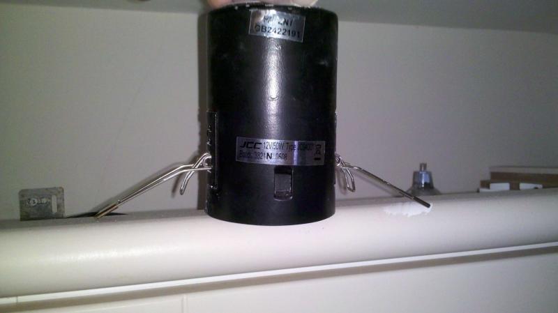 JCC fire-rated downlight fitting showing twin-tong spring clips used to hold it in the ceiling
