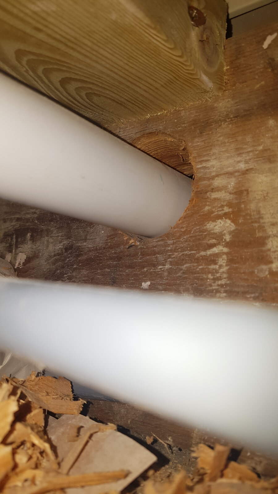 Bathroom floor loading waste pipe running through each joist