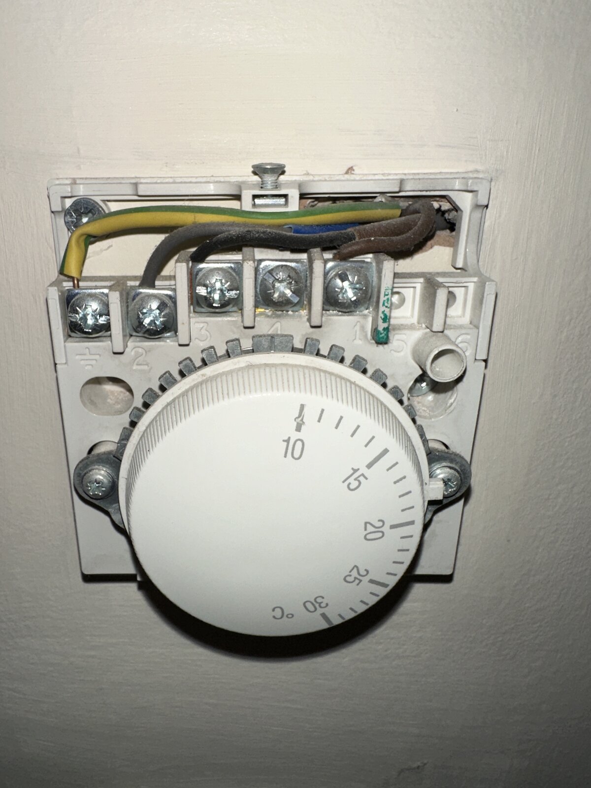 An image of the original Honeywell thermostat, with the wiring exposed.
