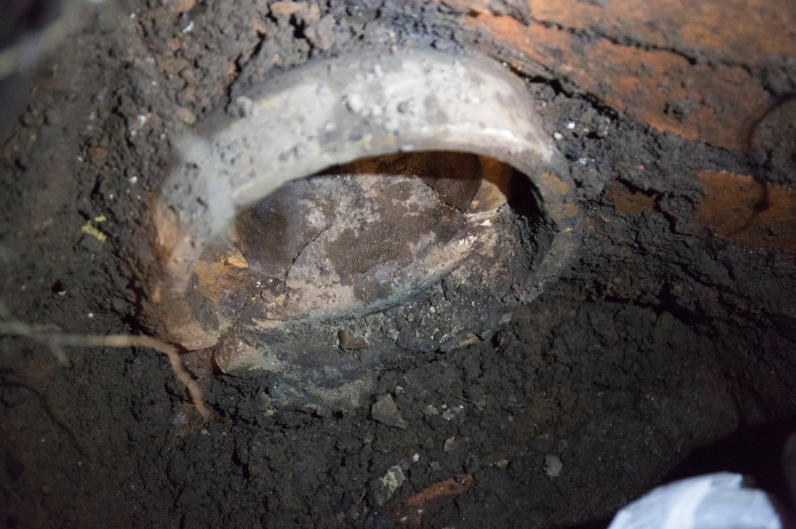 Old cracked clay pipe embedded in sewer wall.jpg