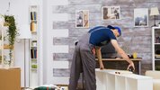 imageye___-_imgi_1_furniture-assembly-worker-standing-reading-instruction-using-tape-measure-...jpeg