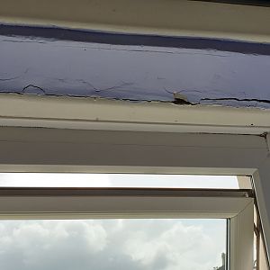 The top of the window and the wooden panel.