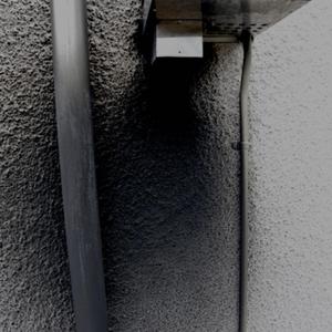 Black fume damage to wall and downpipe