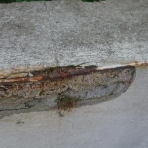 rusting metal edge pushed out cement